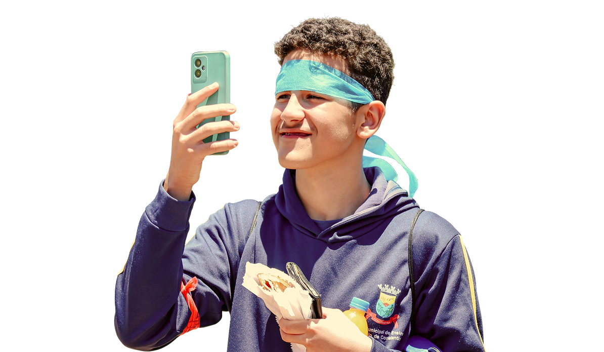 Estudante segurando o celular durante atividade do Manager Kids